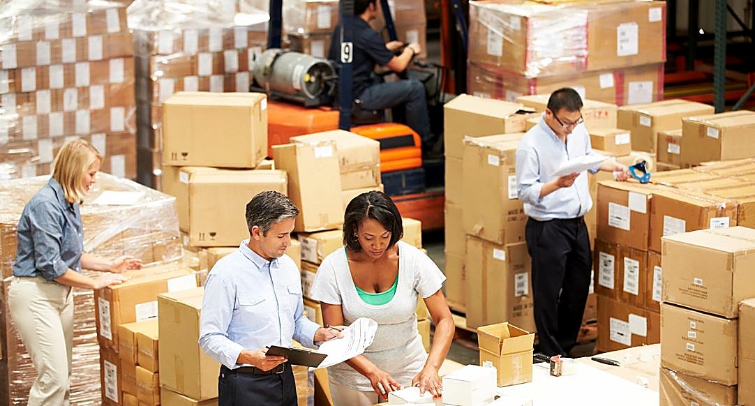 A team reviewing paperwork in a busy warehouse